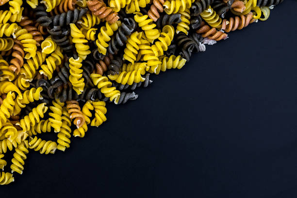 Uncooked pasta fusilli in different colours