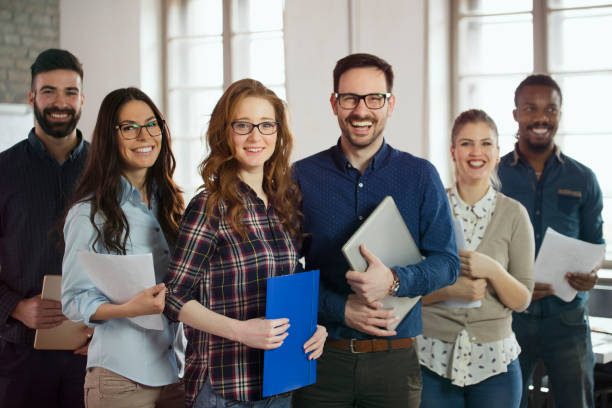 Group picture of young successful team of designers Group picture of young successful team of designers posing in office benefits photos stock pictures, royalty-free photos & images