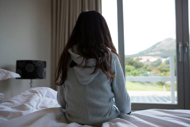 istock Rear view of girl sitting on bed 838371676