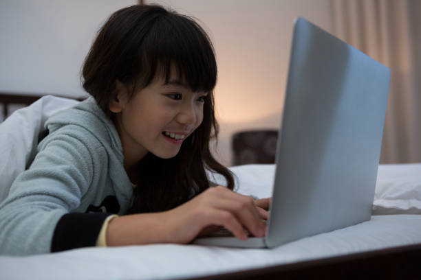 istock Smiling girl using laptop on bed 838371870