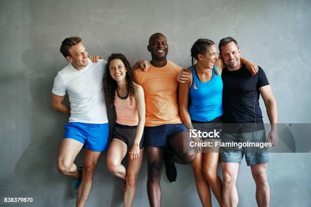 Foto de Diversos Amigos No Sportswear Rindo Juntos Em Uma Academia e mais fotos de stock de Exercício físico