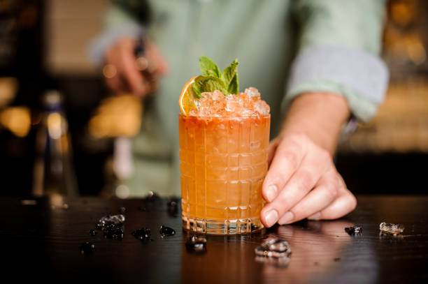 barkeeper beendet seinen cocktail dekoration - orange frucht fotos stock-fotos und bilder