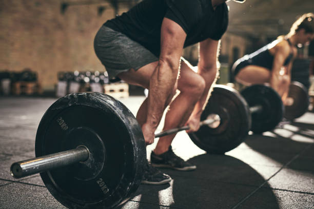 hombre fuerte haciendo peso muerto con entrenamiento en gimnasio - entrenamiento con pesas fotografías e imágenes de stock