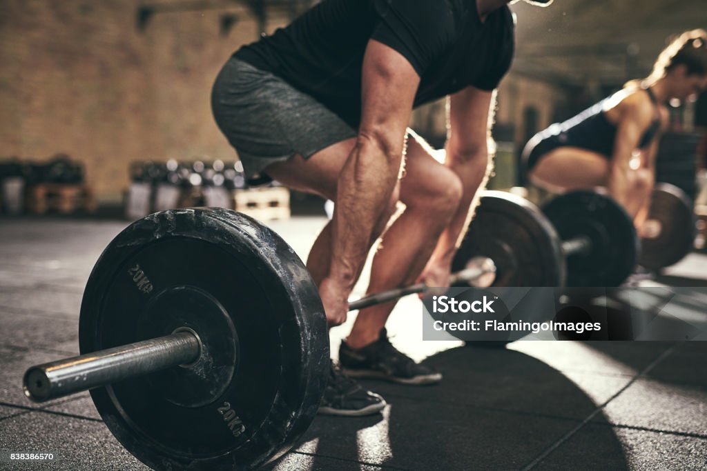 Strong man doing deadlift training in gym Fit people doing deadlift exercise in gym. Horizontal indoors shot Exercising Stock Photo