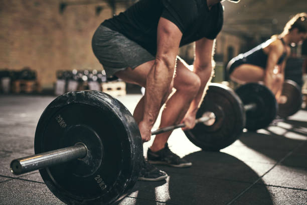 Strong man doing deadlift training in gym stock photo