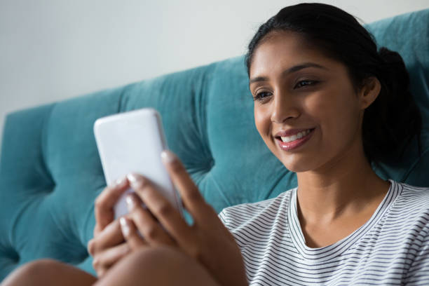 istock Smiling woman using phone in bedroom 838386654