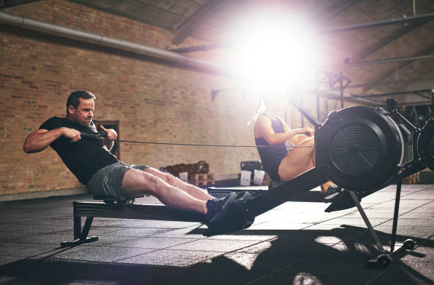 istock Two sportsmen training hard on rowing machines 838388924
