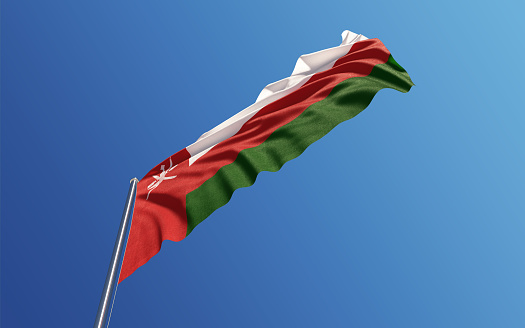 High quality 3d render of an Omani flag waving with wind on a blue sky. Low angle view with copy space. Clipping path is included. Great use for Omani politics and Omani culture related concepts. Horizontal composition.