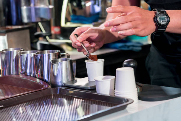 Barista checking fine ground coffee to optimize the grinder