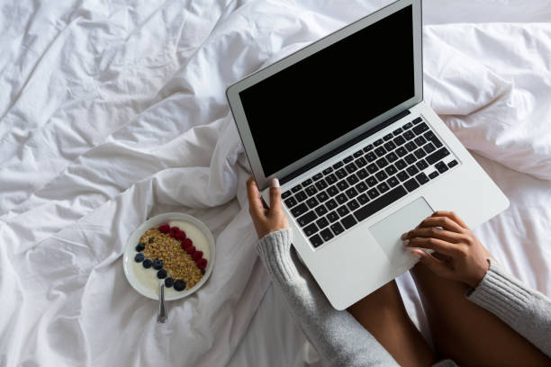 istock Cropped image of woman using laptop while resting on bed 838398324
