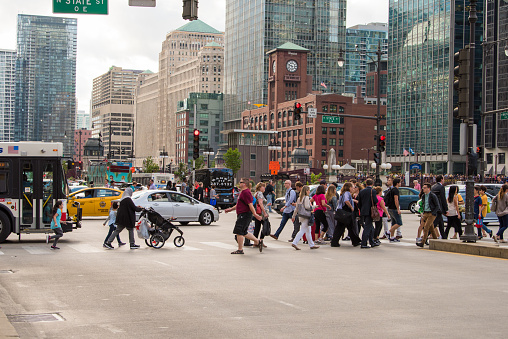 Chicago, IL, August 17, 2017: A throng of people cross the street during rush hour, downtown Chicago. More than half a million people work downtown.