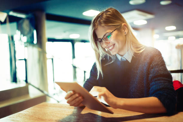 istock Happy young woman using tablet at coffee shop 838400136