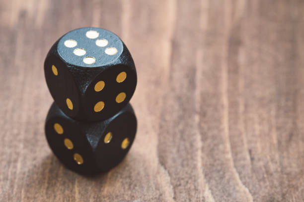 istock Close-up of black dice on a wooden table 838401956
