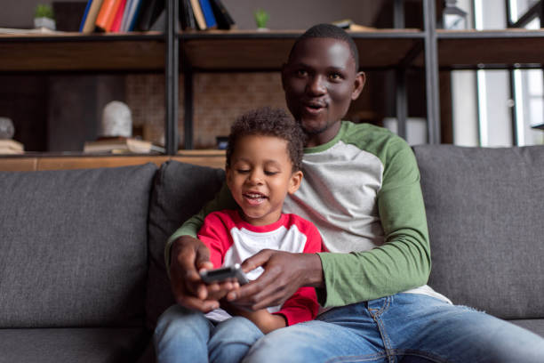 istock father and son watching tv 838403070