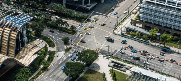 istock cars in intersection with public park and building 838405760