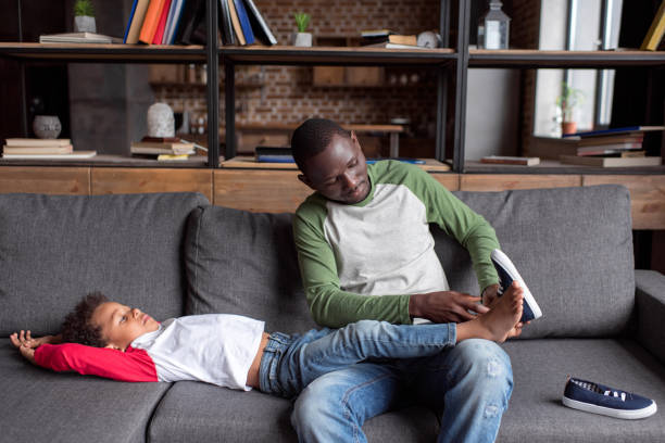 istock father putting shoes on son 838409616