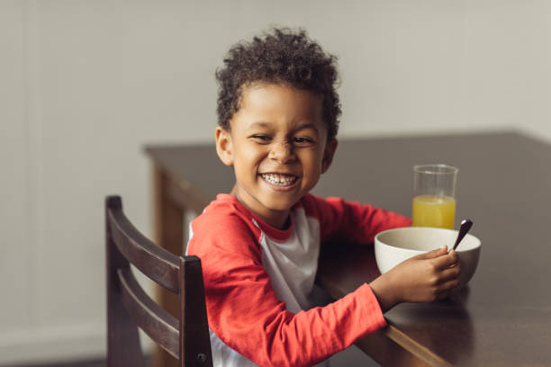 kid eating healthy breakfast smiling african american kid eating healthy breakfast boys bowl haircut stock pictures, royalty-free photos & images