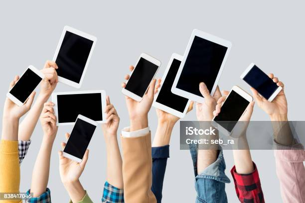 Hands Raising Technological Devices Stock Photo - Download Image Now - Large Group Of Objects, Smart Phone, Crowd of People