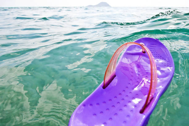 istock Rubber beach slippers on the water surface, seashore with waves, relaxation vacation pleasure bliss background 838417422