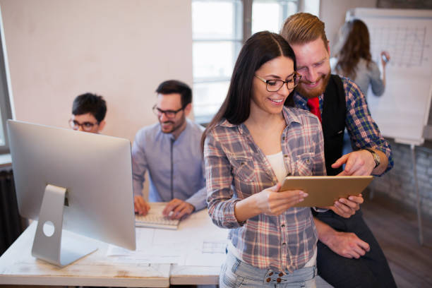 istock Young attractive designers talking and looking at digital tablet 838424710
