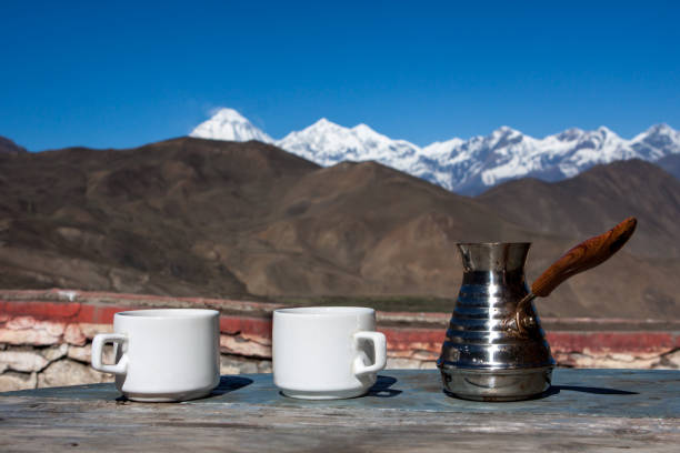 kaffee trinken mit atemberaubendem blick auf die berge. schöne himalaya-landschaft mit kaffeetassen und cezve. kaffee trinken draußen auf einer schneebedeckten landschaft. - muktinath stock-fotos und bilder