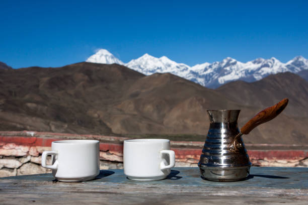 beber café con impresionantes vistas a la montaña. hermoso paisaje del himalaya con tazas de café y cezve. beber café fuera sobre un fondo de paisaje nevado. - muktinath fotografías e imágenes de stock