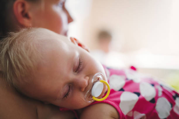 istock Young mother holding her sleeping newborn baby 838438782
