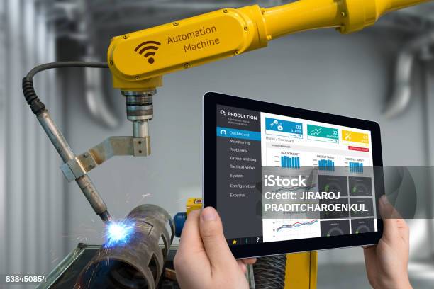 Engineer Hand Using Tablet Heavy Automation Robot Arm Machine In Smart Factory Industrial With Tablet Real Time Monitoring System Application Industry 4th Iot Concept Stock Photo - Download Image Now