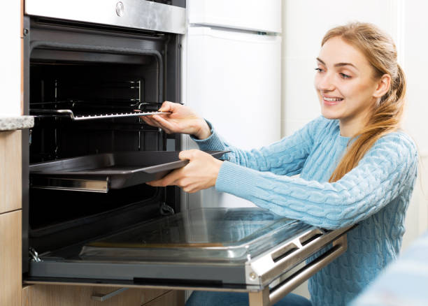 istock Woman placing roasting tray in kitchen oven 838461764