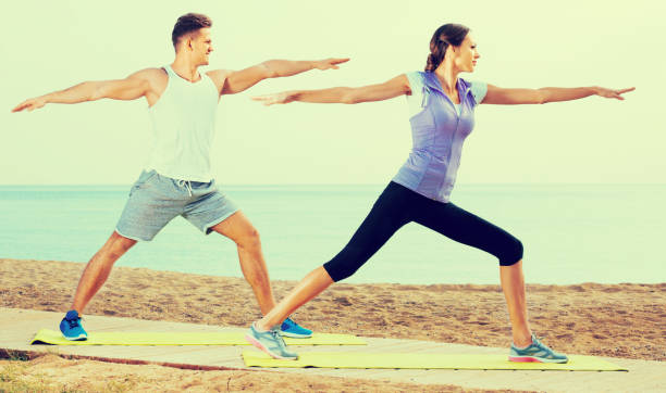 istock Couple do exercises on beach by ocean at daytime 838461818
