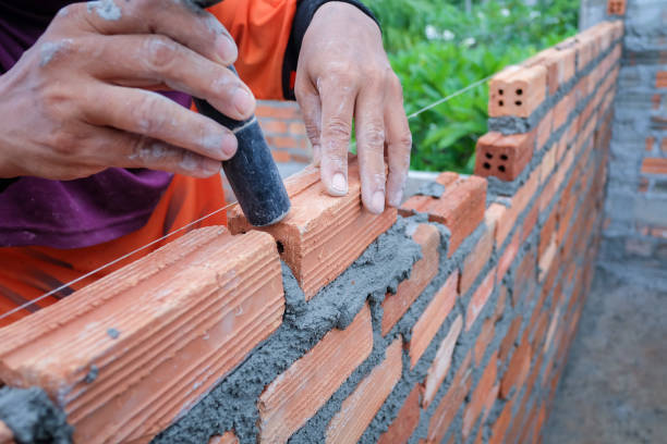 istock The hands of the construction workers are building a brick red brick wall 838472162