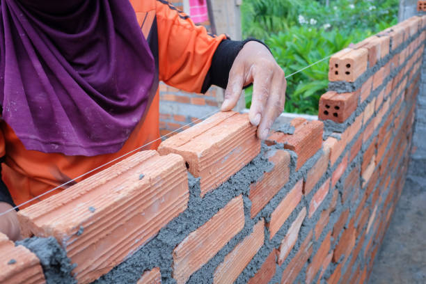 istock The hands of the construction workers are building a brick red brick wall 838472172