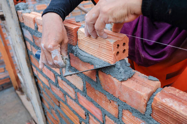 istock The hands of the construction workers are building a brick red brick wall 838472184
