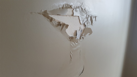 Paint is peeling away from the drywall.