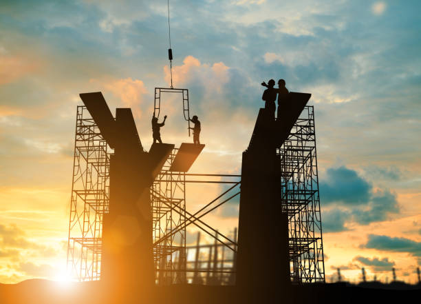 Silhouette engineer  look team construction safely to work load scaffolding over blurred background sunset pastel for industry background with Light fair