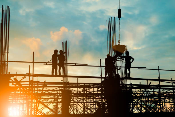 istock Silhouette of engineer and construction team working safely work load concrete on scaffolding on high rise building. over blurred background sunset pastel for industry background with Light fair 838474668