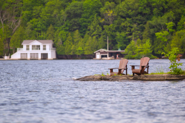 istock Muskoka chairs on a rock formation facing a calm lake 838476980