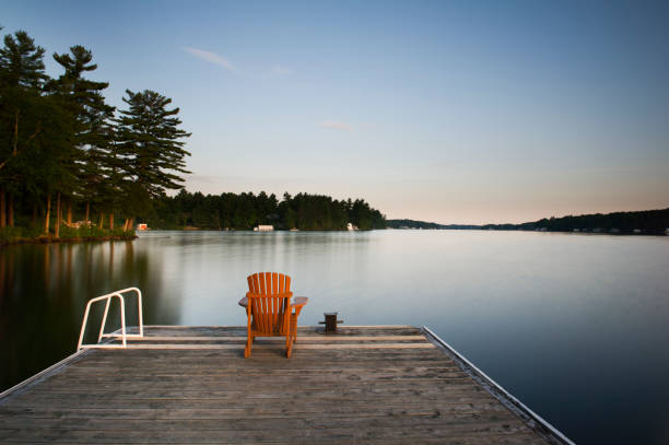 istock Muskoka chairs sitting on a wooden dock 838477786