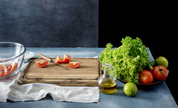 istock Kitchen table with cutting board, salad bowl and vegetables 838482244