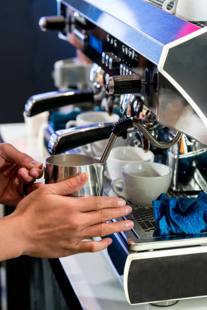 istock Asian barista steaming fresh milk in stainless pitcher with vent pipe 838483432