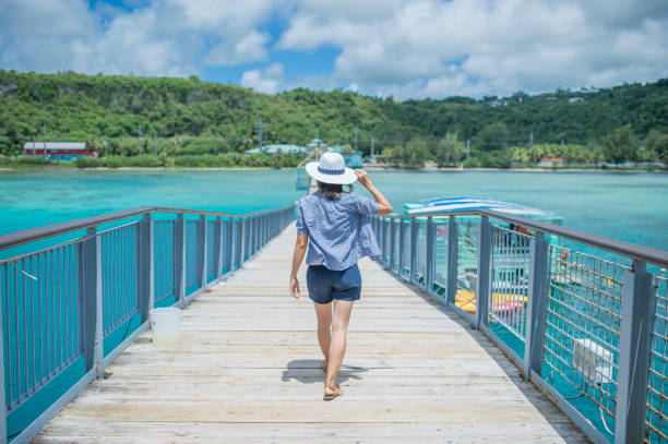 средний взрослый человек ищет море с улыбкой - guam стоковые фото и изображения