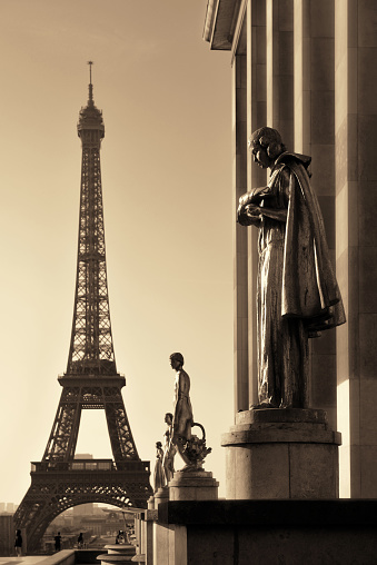 Eiffel Tower with statue as the famous city landmark in Paris