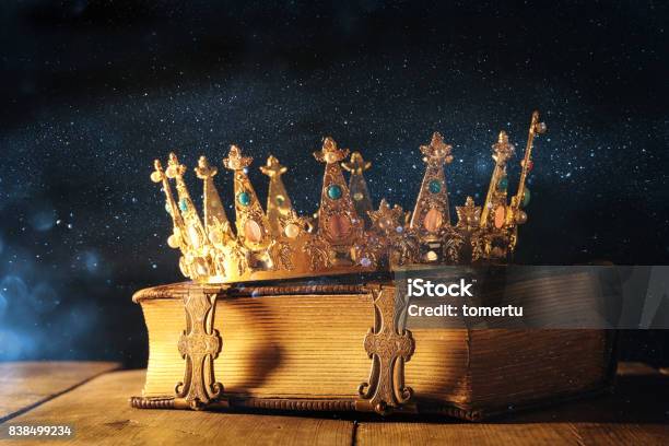 Low Key Of Queen King Crown On Old Book Vintage Filtered Fantasy Medieval Period Stock Photo - Download Image Now