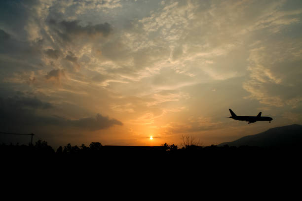 istock Airplane Landing with Yellow sky sunset background 838501724