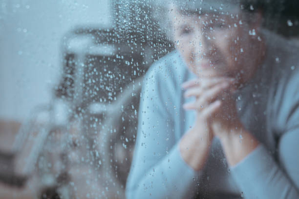 personnes âgée dame assise - women depression window sadness photos et images de collection