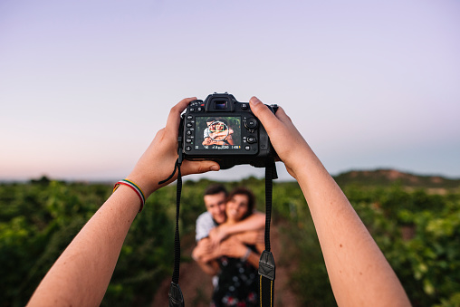 A DSLR camera capturing a young couple outdoors