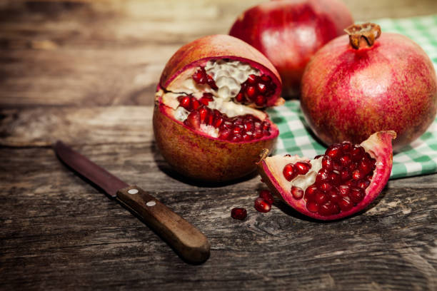 istock Red juicy pomegranate with knife on the table 838507334