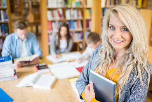 istock Female student with others in background at library 838511972