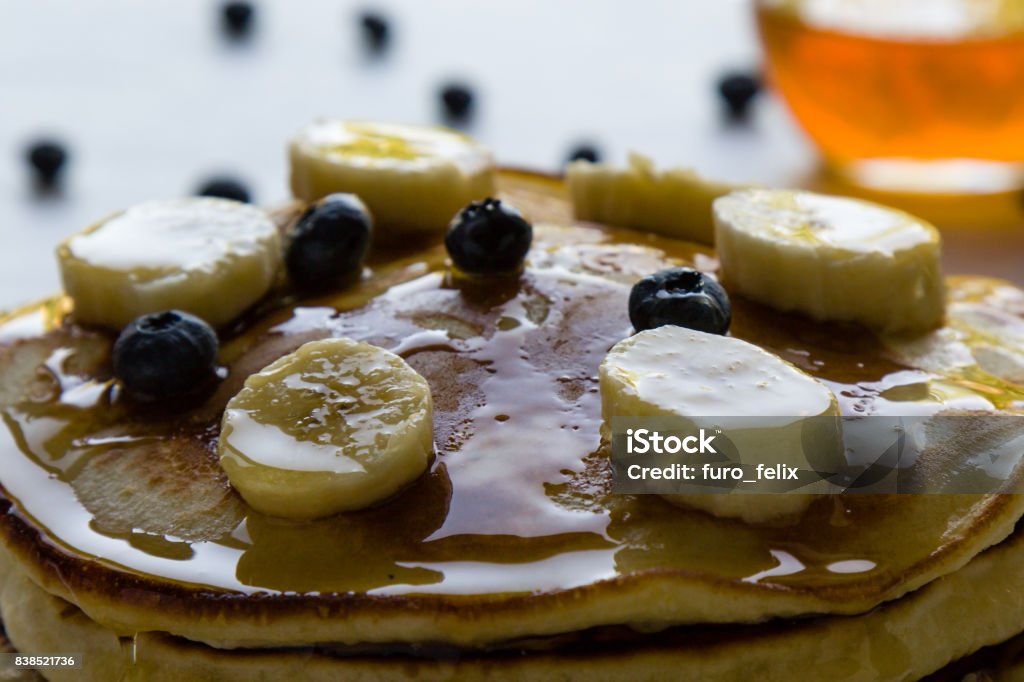 pancakes in morning light pancakes with banana, blueberry and honey in morning light Baked Stock Photo