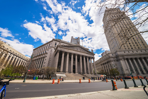 New York, USA - April 24, 2015: Street view on Thurgood Marshall United States Courthhouse and New York State Supreme Building, or New York County Courthouse, in Lower Manhattan, NYC. Tourists nearby.